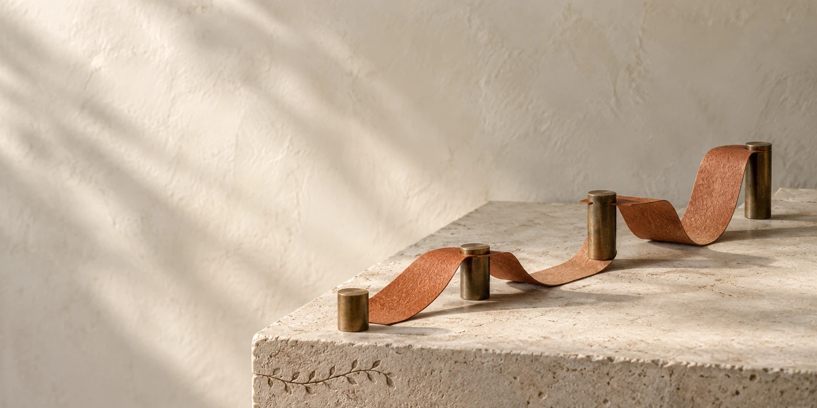 Studio visivo Bottega: un nastro terracotta collega quattro punti su pietra chiara